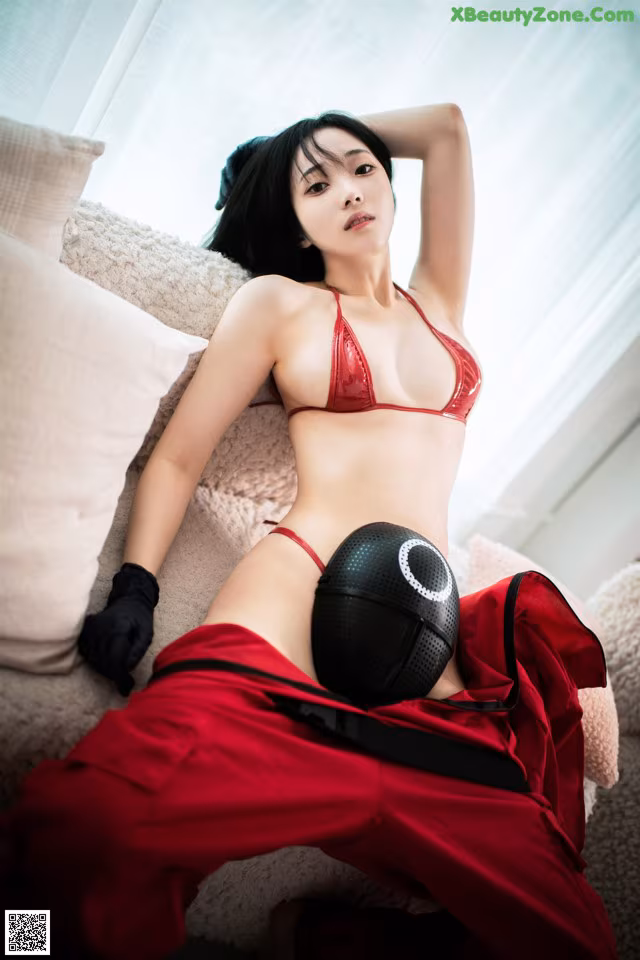 A woman in a red bikini laying on a couch.