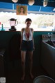 A woman standing in a kitchen next to a stove.