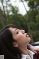 A woman with long black hair and a white shirt.