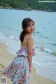 A woman standing on a beach next to the ocean.